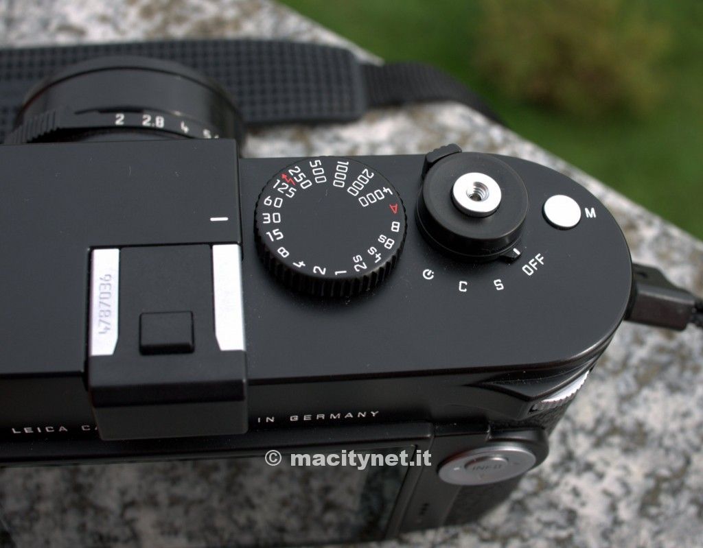 Classica disposizione delle ghiere superiori, con ghiera dei tempi e pulsante di scatto. Di fianco il tasto dedicato ai video.