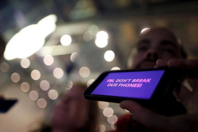 A man displays a protest message on his iPhone at a small rally in support of Apple's refusal to help the FBI access the cell phone of a gunman involved in the killings of 14 people in San Bernardino, in Santa Monica
