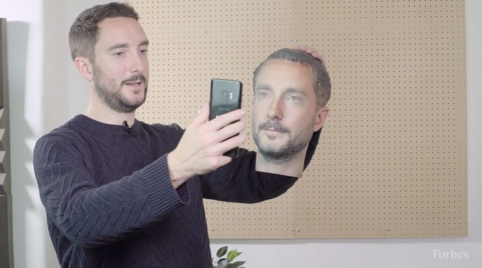 Il redattore di Forbes mentre prova a sbloccare uno smartphone ingannandolo con il volto ricostruito in 3D