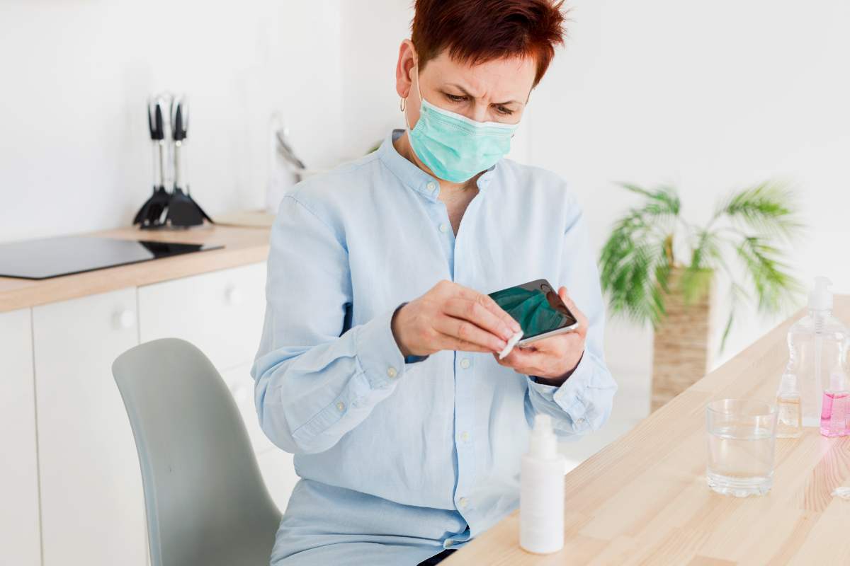 Persona che pulisce il telefono Alcol al 70% e pochi secondi