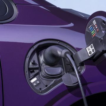 Photograph shows open Nissan PIXO fuel-filler compartment on a glossy purple car, highlighting vehicle refueling components.